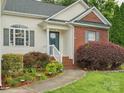 Close up of the front entrance with well-kept landscaping, walkway, and a blue door with white trim at 116 Birchwood Ct, Mount Holly, NC 28120