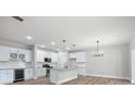 A stylish kitchen boasts granite countertops, white cabinets, stainless steel appliances, and modern lighting at 12526 Susanna Dr, Charlotte, NC 28214