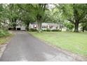Cozy home with a long driveway leading to a detached garage, all nestled among mature shade trees at 1270 N Enochville Ave, China Grove, NC 28023