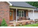 Close up of welcoming front porch with chairs and potted plants on charming brick home at 1483 Dawnview Ln, Lincolnton, NC 28092