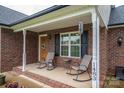Cozy front porch with chairs and decorations, set on a brick home with a welcoming entrance at 1483 Dawnview Ln, Lincolnton, NC 28092