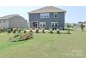 Large backyard with lush green grass, patio seating, and landscaping, perfect for outdoor enjoyment at 151 Outrigger Ln, Troutman, NC 28166