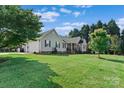 Well-kept home with an attached garage, surrounded by a spacious, green lawn and mature trees at 166 Rumple Hill Dr, Statesville, NC 28677