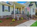 Inviting front porch with brick accents, decorative plants, and comfortable seating, enhancing curb appeal at 166 Rumple Hill Dr, Statesville, NC 28677