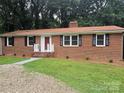 Traditional brick house with black shutters, a red front door, and a well-maintained lawn at 1660 Songwood Rd, Concord, NC 28025