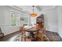 Formal dining room with a round wood table and bright natural light from large windows at 2034 Houle Ln, Charlotte, NC 28214