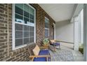 Inviting front porch with cozy seating, decorative rug, and brick accents, perfect for relaxing outdoors at 2034 Houle Ln, Charlotte, NC 28214