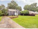 Lovely home has mature trees, green grass, and a concrete driveway leading to the light blue front door at 2421 Morton St, Charlotte, NC 28208