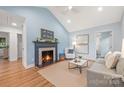 Inviting living room features a fireplace, wood floors, light blue walls, and vaulted ceilings at 2421 Morton St, Charlotte, NC 28208