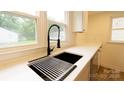 Modern kitchen sink with stainless steel rack, white countertops, and a stylish black faucet at 301 Carolina Blvd, Salisbury, NC 28146