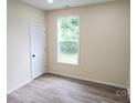 Cozy bedroom showcasing wood-look flooring, a large window and neutral walls at 306 E Ratchford Ave, Gastonia, NC 28054