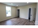 Bright bedroom with wood-look flooring and a large window offering ample natural light at 306 E Ratchford Ave, Gastonia, NC 28054