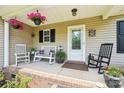 Cozy front porch with rocking chairs, hanging flower baskets, and a welcoming entrance at 320 Bluegill Ln, Statesville, NC 28625