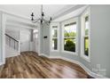 Dining area with large windows, hardwood floors, and a modern chandelier at 3902 Mcgee Point Rd, Terrell, NC 28682