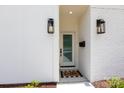 Front door with black hardware, modern light fixtures, and a brick surround at 4203 Walker Rd, Charlotte, NC 28211