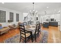 Open dining room showcasing hardwood floors, chandelier, and view to the kitchen at 4644 Snow Dr, Harrisburg, NC 28075