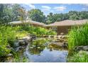 A serene pond is surrounded by lush greenery, adding a peaceful touch to the landscape at 5424 Doncaster Dr, Charlotte, NC 28211
