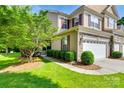 Beautifully landscaped front yard with lush green grass, mature trees, and manicured hedges leading to the house at 714 Deerbrook Ln, Tega Cay, SC 29708