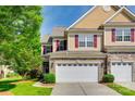 Charming townhome exterior with stone accents, a two-car garage, and well-manicured landscaping at 714 Deerbrook Ln, Tega Cay, SC 29708