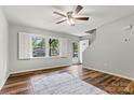 View of the living room featuring wood floors, a window with white shutters, and an entry door at 729 Tenth Ne Ave, Hickory, NC 28601