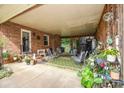 Relaxing covered patio, ideal for outdoor seating and entertainment, with plants and brick accents at 7518 Surry Ln, Indian Trail, NC 28079