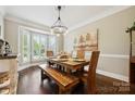 Bright dining room featuring hardwood floors, a bay window, and a rustic dining set at 8109 Hawk Crest Ct, Charlotte, NC 28270