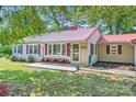 Inviting home with a red metal roof, cozy front porch, and well-maintained landscaping at 8255 Castor Rd, Salisbury, NC 28146