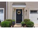 Close up of front door and entryway with wreath, landscaping, and single car garage at 999 Rushing Ln # 13, Fort Mill, SC 29715