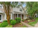 Inviting townhome with lush landscaping, a brick facade, and a charming covered front porch at 10223 Reindeer Way Ln, Charlotte, NC 28216
