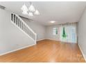 Bright living room featuring wood floors, stairs, a large glass sliding door and neutral walls at 10223 Reindeer Way Ln, Charlotte, NC 28216