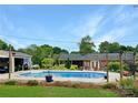 Backyard pool area with mature landscaping, brick home with patio, and outbuilding at 110 Heritage Dr, Kings Mountain, NC 28086