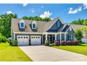 Attractive exterior view showcasing a well-maintained home with a two-car garage and beautifully landscaped front yard at 129 Hawks Creek Pkwy, Fort Mill, SC 29708
