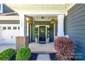 Close up view of the front porch with hanging floral arrangements and well-manicured greenery at 129 Hawks Creek Pkwy, Fort Mill, SC 29708