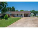Charming brick home featuring a well-manicured lawn, long driveway, and barn at 1613 Spangler Dr, Shelby, NC 28150