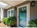 Close-up of the teal front door framed by decorative plants and classic wall lanterns at 2024 5Th Street Nw Pl, Hickory, NC 28601