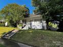 Charming home featuring a covered porch, brick chimney, and landscaped front yard at 208 S Ransom St, Gastonia, NC 28052