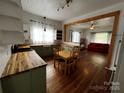 Open kitchen layout with a dining area, butcher block countertops, and updated lighting fixtures at 208 S Ransom St, Gastonia, NC 28052