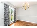 Dining room with hardwood floors, decorative chandelier, and large window with patterned drapes at 270 Kilmer Ln, Mooresville, NC 28115