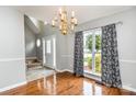 Dining room with hardwood floors, decorative chandelier, and large window with patterned drapes at 270 Kilmer Ln, Mooresville, NC 28115