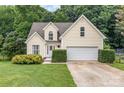 Charming yellow home featuring an attached garage and a beautifully landscaped front yard at 270 Kilmer Ln, Mooresville, NC 28115