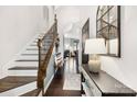 Elegant foyer featuring hardwood floors, a staircase with wood and wrought iron, and stylish console table decor at 344 Kennebel Pl, Fort Mill, SC 29715