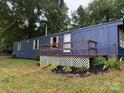 The side of a blue manufactured home with a small porch at 41042 Dennis Rd, Albemarle, NC 28001