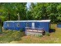 Exterior view of blue mobile home with a white porch and green lawn at 41042 Dennis Rd, Albemarle, NC 28001
