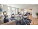 Bright living room features three seating chairs with blue pillows, a modern rug, and views of the kitchen at 509 Abelia Ln, Fort Mill, SC 29708