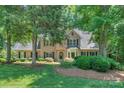 Beautiful brick home with mature landscaping, bay window and black shutters on a lush lawn at 5485 Deer Run Ct, Davidson, NC 28036