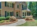 Charming brick home with black door, bay window and manicured front garden at 5485 Deer Run Ct, Davidson, NC 28036