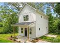 Charming two-story home with white siding, a covered porch, and simple landscaping at 605 Poplar St, Shelby, NC 28150
