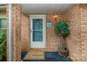 Close-up of the front door with a brick facade, a potted plant, and a welcome mat at 6577 Stoney Ridge Rd, Matthews, NC 28104