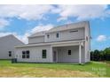 The back of a two-story gray home with a covered patio and green grass at 7225 Jerimoth Dr, Charlotte, NC 28215