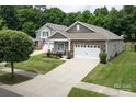 Beautiful home showcasing a stone facade, two-car garage, and lush green lawn at 7328 Strawberry Fields Ln, Charlotte, NC 28278